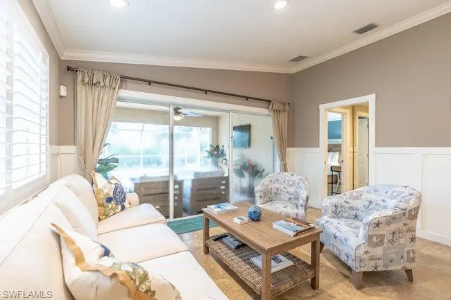 Living room with ornamental molding and ceiling fan