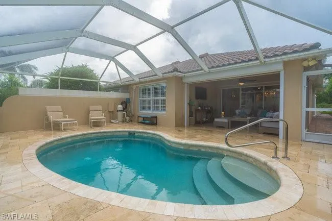 View of swimming pool featuring a lanai, a patio area, and ceiling fan