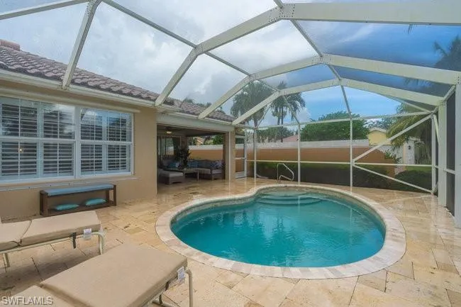 View of swimming pool featuring glass enclosure, a patio area, and outdoor lounge area