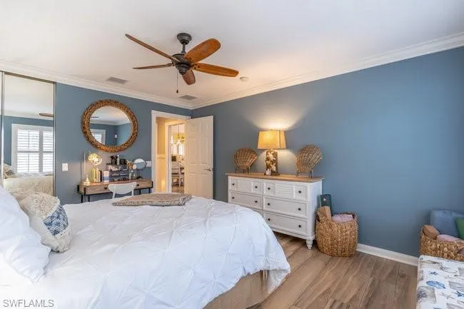 Bedroom with crown molding, light hardwood / wood-style flooring, and ceiling fan