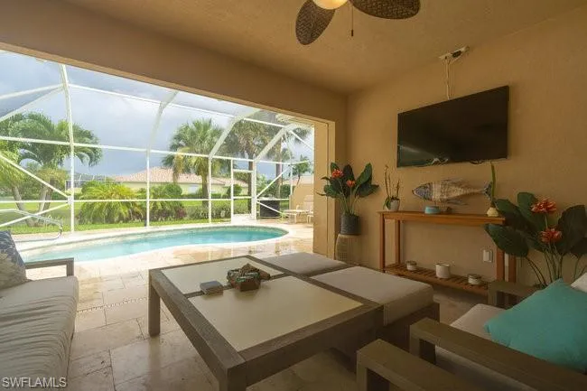 View of swimming pool featuring a patio, a lanai, and ceiling fan