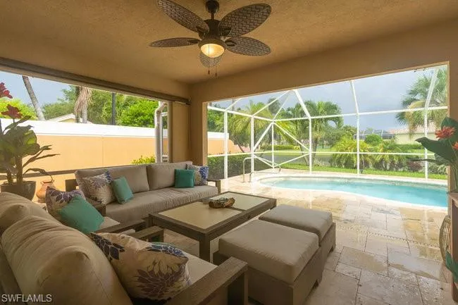View of swimming pool featuring a patio, an outdoor hangout area, a lanai, and ceiling fan