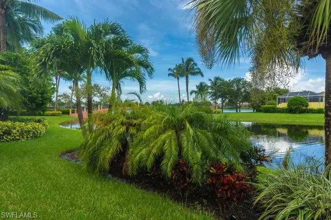 Surrounding community with a water view and a lawn