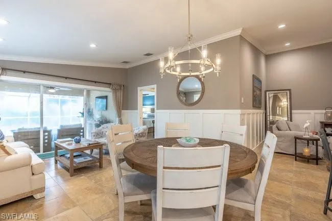 Tiled dining room with a notable chandelier and ornamental molding