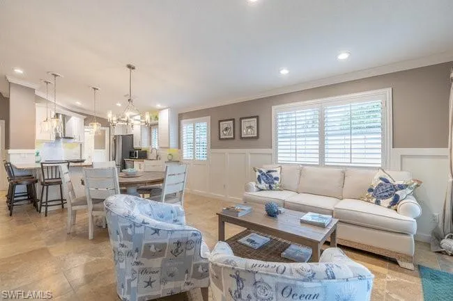 Tiled living room featuring a chandelier and ornamental molding