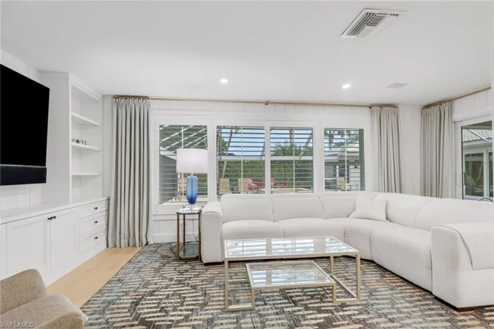 Living room featuring built in shelves and light wood-type flooring