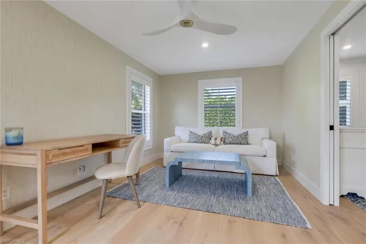 Office space featuring light wood-style floors, a ceiling fan, and wallpapered walls