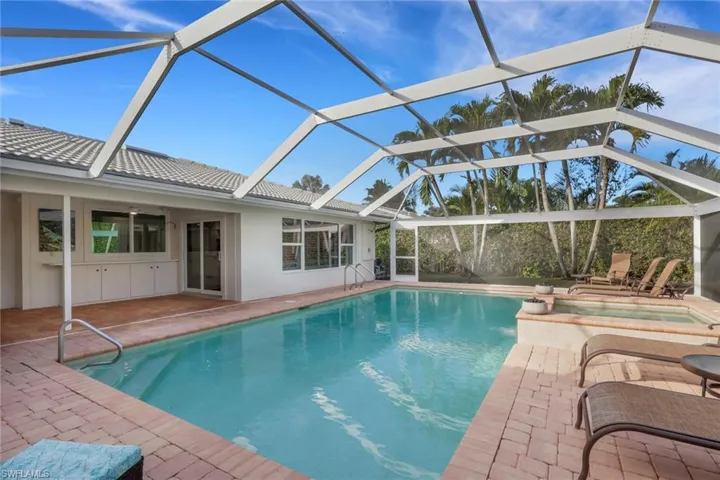Swimming pool with a sunroom, an in-ground hot tub, a patio area, and a lanai