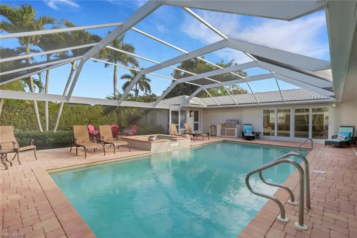 View of pool with a patio area, a sunroom, a lanai, and a pool with connected hot tub