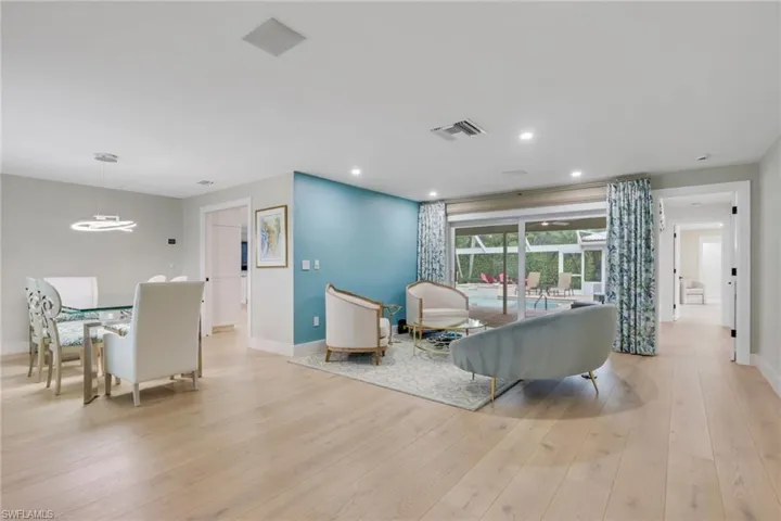 Living area with light wood-type flooring, recessed lighting, and a chandelier