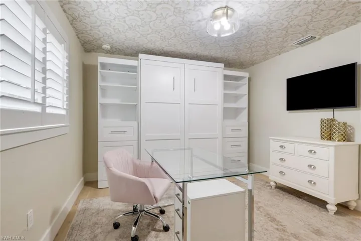 Office space featuring baseboards and light wood finished floors