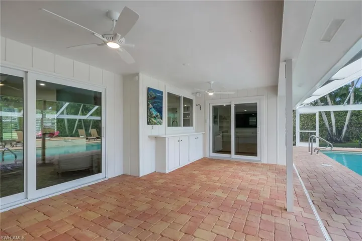 View of patio / terrace with ceiling fan, an outdoor pool, a lanai, and a sunroom