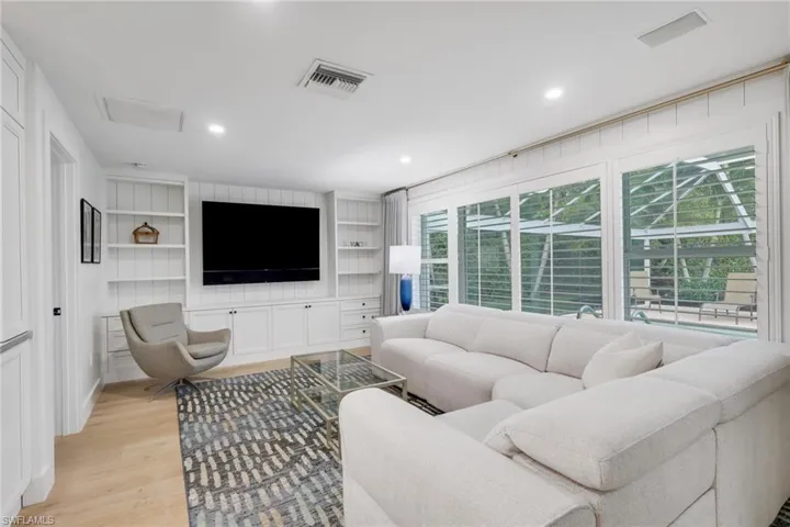 Living area featuring light wood-type flooring, built in shelves, and recessed lighting