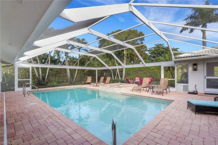 View of pool featuring a lanai, a patio, a sunroom, and a pool with connected hot tub