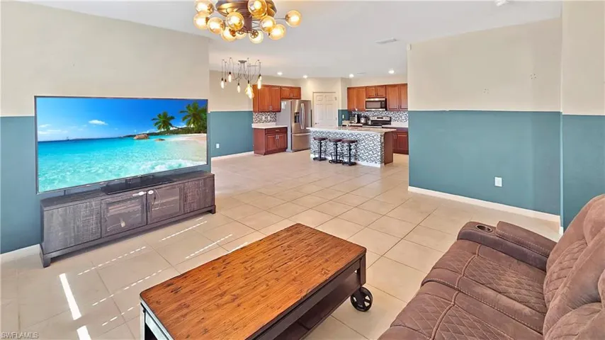 Tiled living room featuring a notable chandelier
