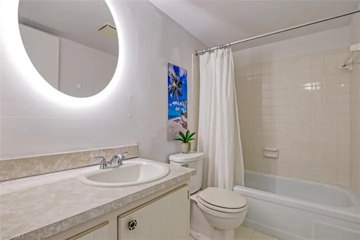 Full bathroom with vanity, tile patterned floors, shower / bath combo, and toilet