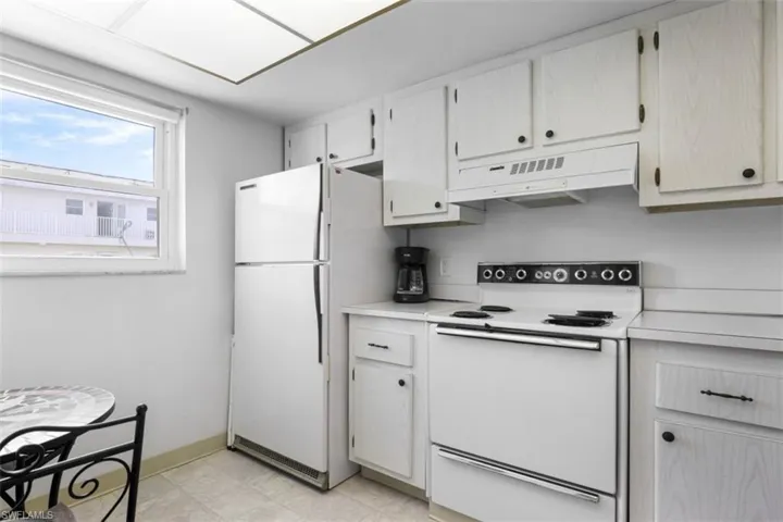 Kitchen with white appliances and light tile patterned floors