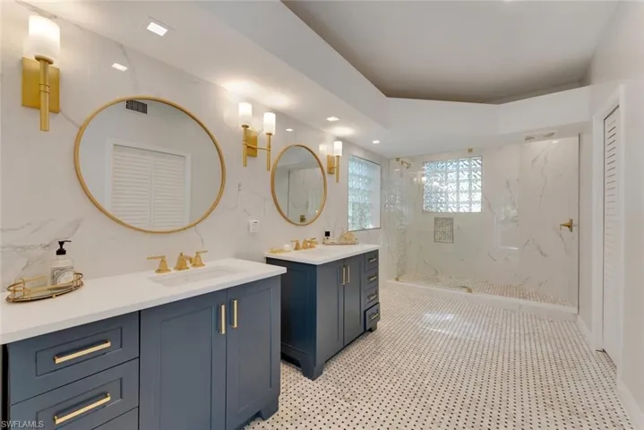 Master Bathroom featuring tiled shower, dual sink vanity, and tile floor
