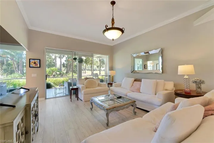 Living room with crown molding and light wood flooring