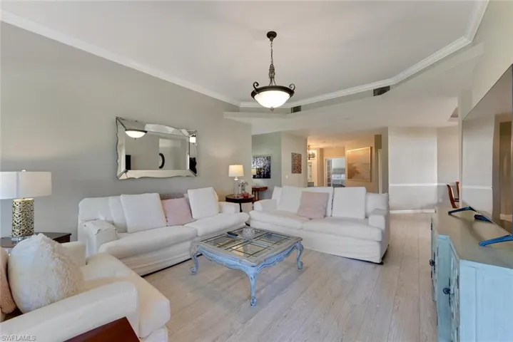 Living room with crown molding and light wood flooring