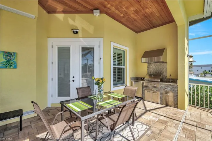 View of patio featuring area for grilling, a grill, outdoor dining area, french doors, and a sink