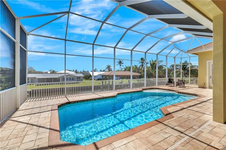 View of pool with a lanai, fence, a fenced in pool, and a patio