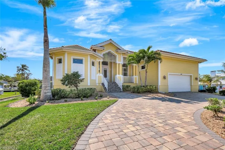 View of front facade with decorative driveway and a front lawn