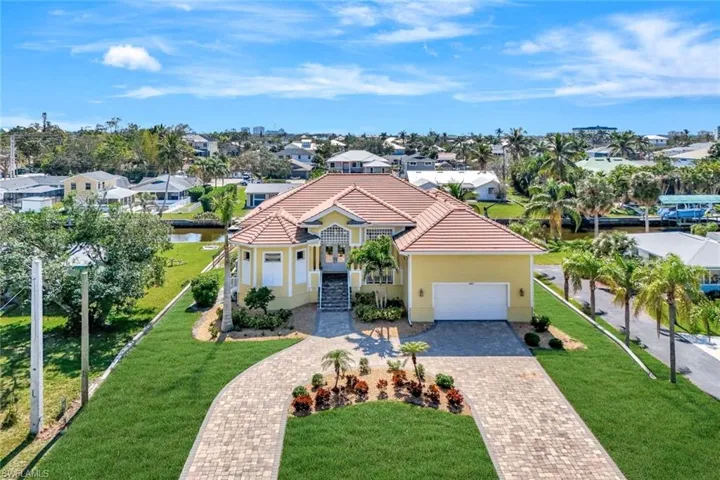 Mediterranean / spanish home featuring decorative driveway, an attached garage, a tile roof, and a residential view
