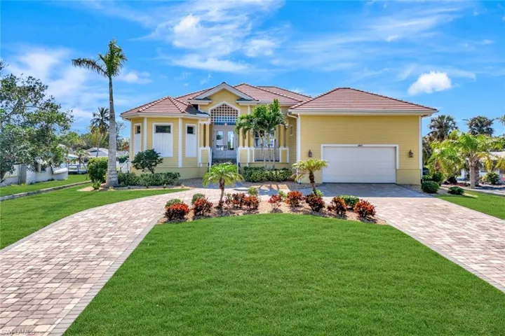 Mediterranean / spanish-style house with decorative driveway, covered porch, a front yard, a garage, and a tiled roof