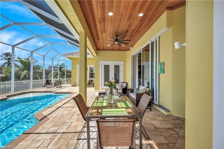 View of patio with a fenced in pool, glass enclosure, ceiling fan, fence, and french doors