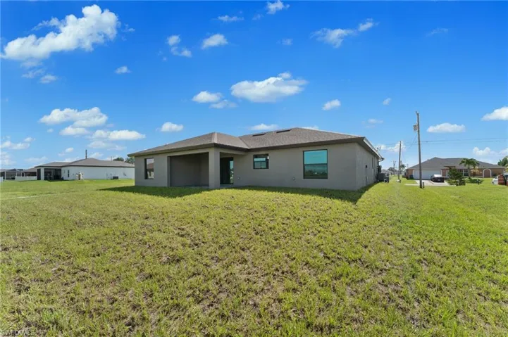 Rear view of house featuring a yard