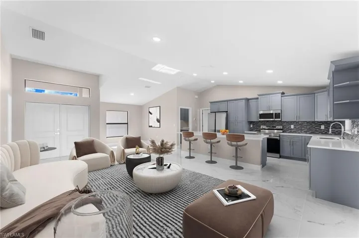 Tiled living room with vaulted ceiling and sink