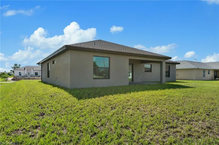 Rear view of house featuring a yard