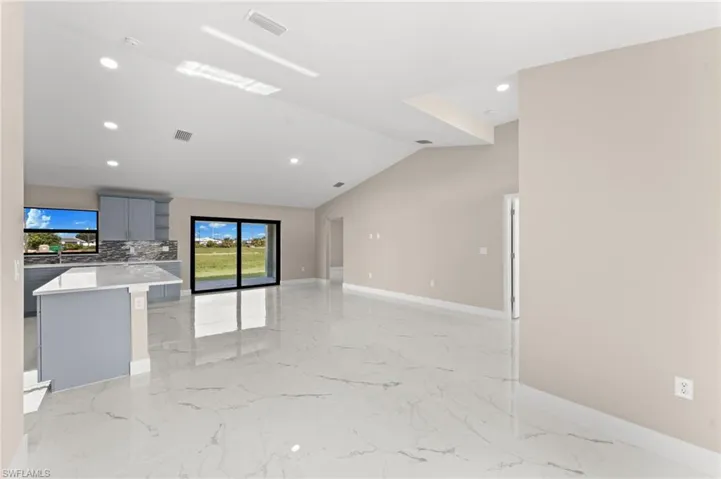 Unfurnished living room with light tile patterned flooring and lofted ceiling