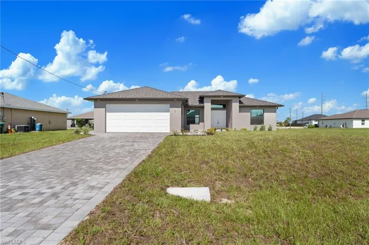 View of front of house with a garage and a front lawn
