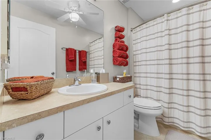 Bathroom featuring a shower with shower curtain, vanity, and a ceiling fan