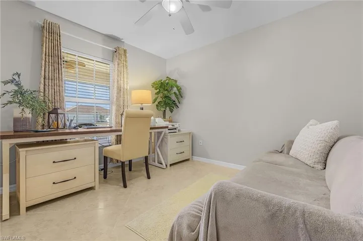 Office with a ceiling fan and light tile patterned floors