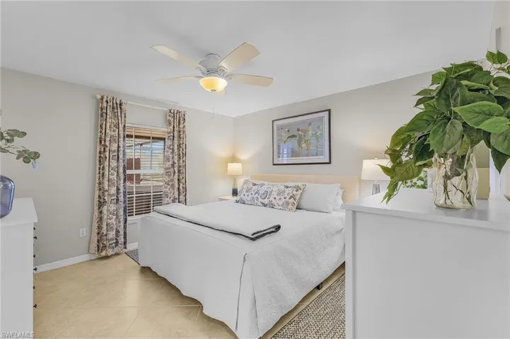 Bedroom with a ceiling fan and light tile patterned floors