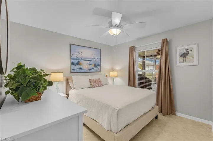 Bedroom with ceiling fan and light tile patterned floors