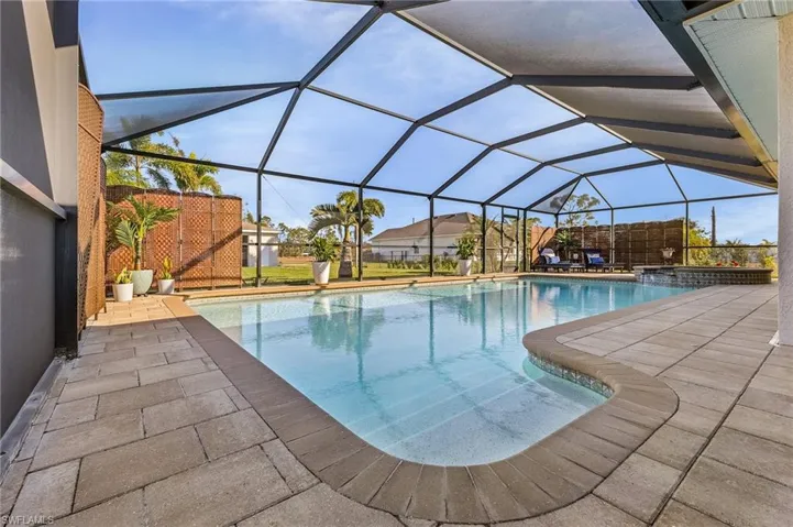 View of swimming pool featuring a lanai, a sunroom, a patio area, and a pool with connected hot tub