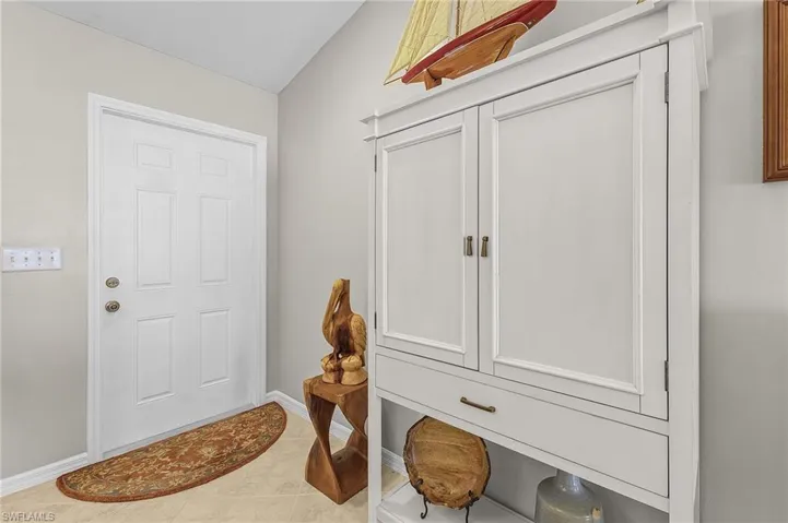 Mudroom featuring light tile patterned flooring and vaulted ceiling