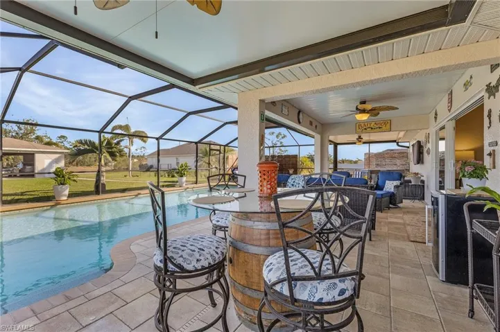 View of patio / terrace with a ceiling fan, a sunroom, an outdoor pool, and a lanai