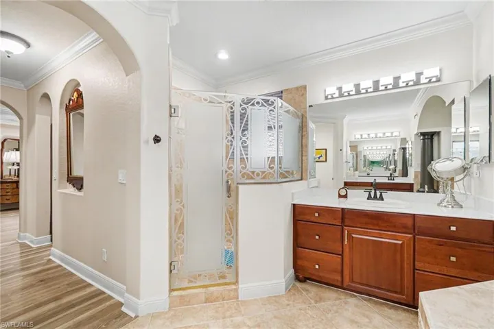 Bathroom featuring a wood-finish double vanity with white countertops and undermount sinks