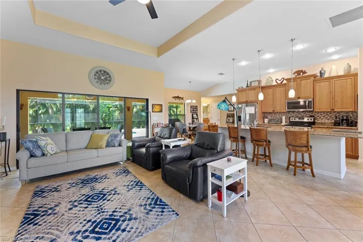 Tiled living room featuring a tray ceiling and a healthy amount of sunlight