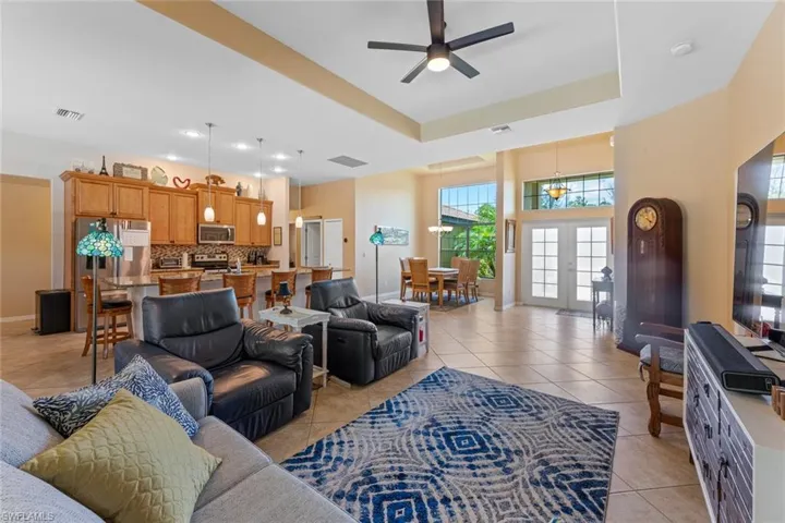 Living room with light tile patterned flooring, a tray ceiling