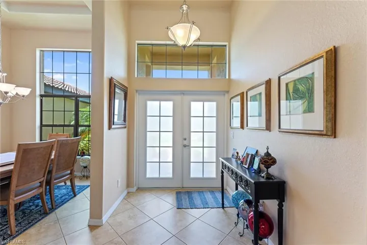 Tiled foyer entrance with French doors and a towering ceiling