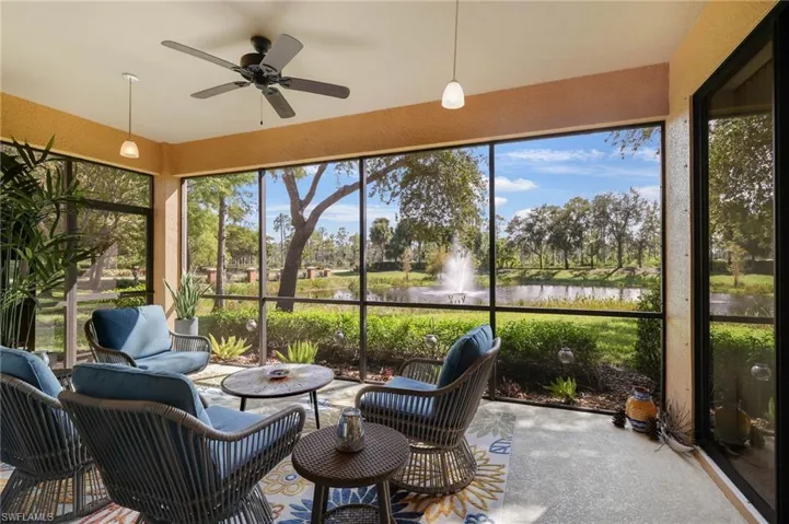 Sunroom / solarium featuring a textured wall, a water view, ceiling fan, and an outdoor hangout area