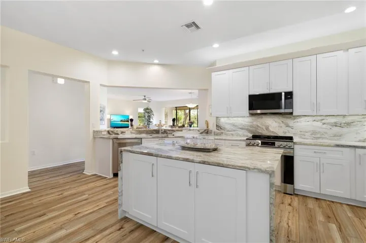Kitchen with white cabinetry, decorative backsplash, recessed lighting, appliances with stainless steel finishes, and light wood finished floors
