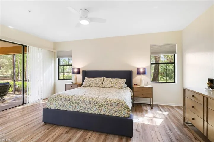 Bedroom with access to exterior, light wood-style floors, and ceiling fan
