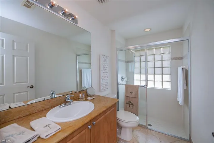 Full bathroom with tile patterned floors, a stall shower, vanity, toilet, and visible vents